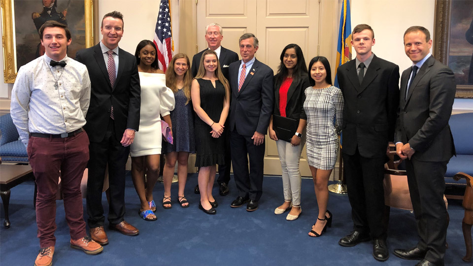 High school seniors posing with workers from NBCUniversal