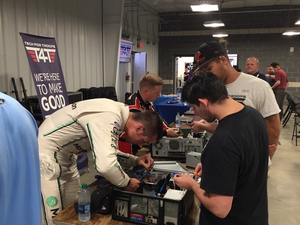 A group of people working on hard drives on a table