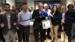 Comcast Beltway region employees in new Xfinity store standing in front of a ribbon