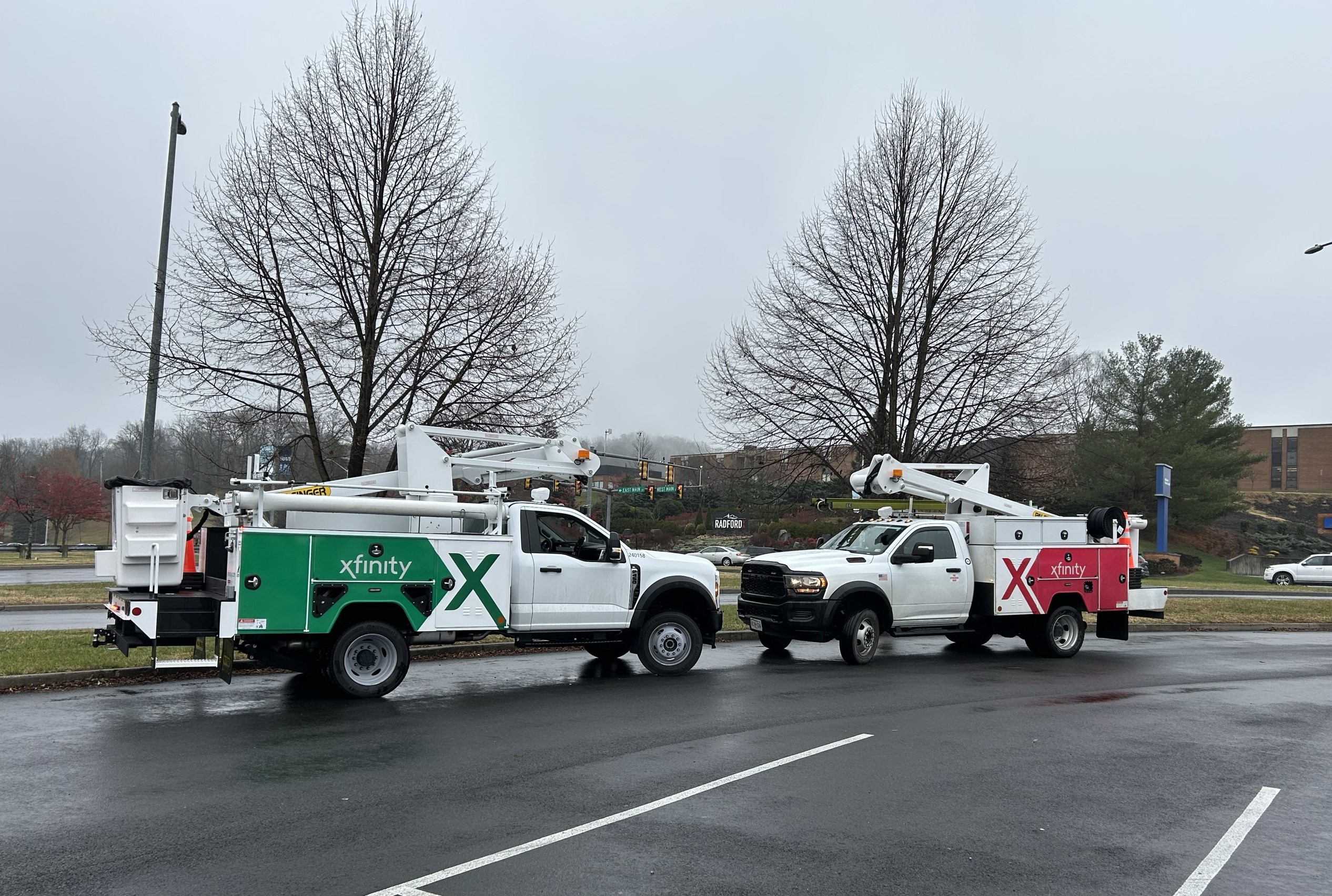 Two Xfinity trucks staging in a parking lot in Rradford.